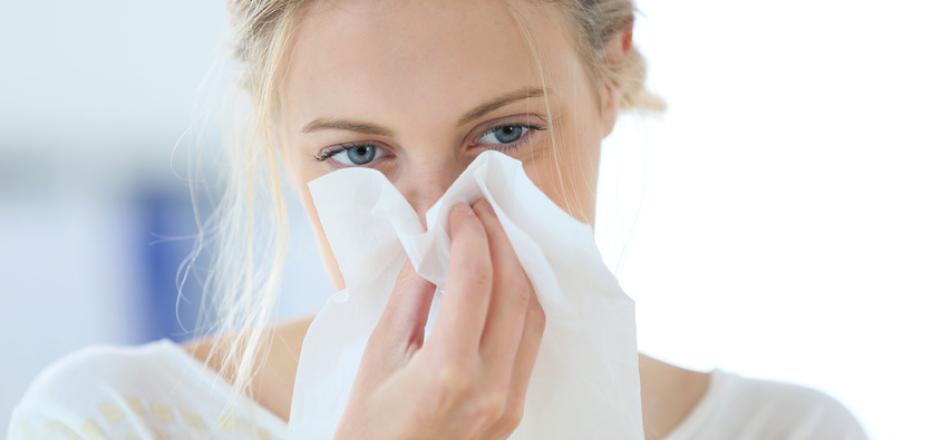 Frau mit einer Pansinusitis putzt sich die Nase